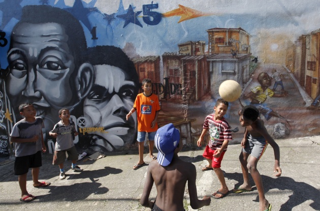 Children play in front of graffiti painted by artists of OPNI in the Vila Flavia favela of Sao Paulo